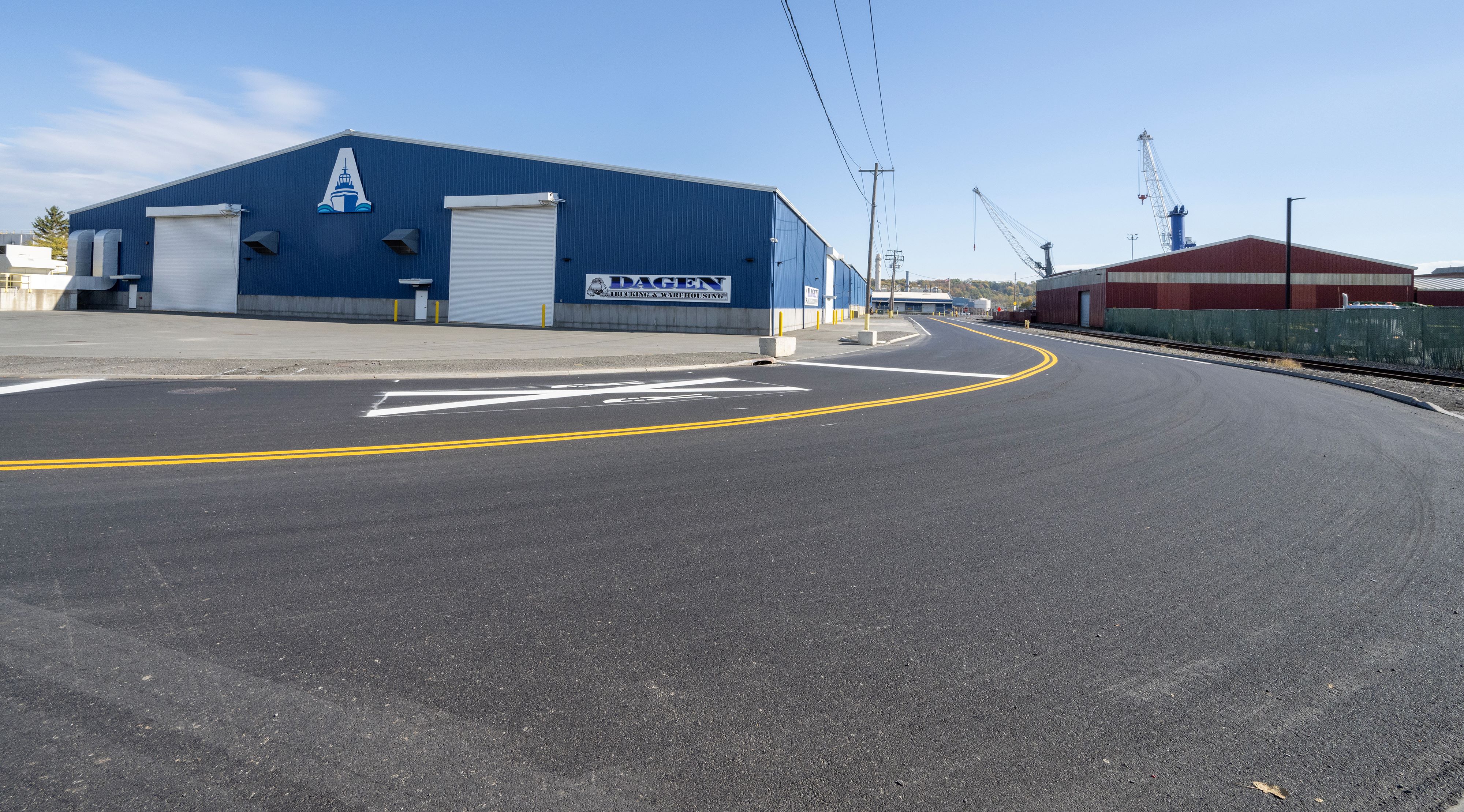 A view from the road of a climate-controlled blue warehouse with white doors