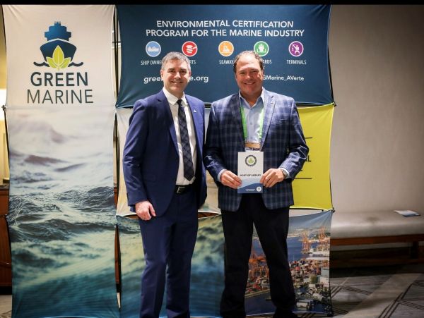 2 men standing in front of a banner with Green Marine logo