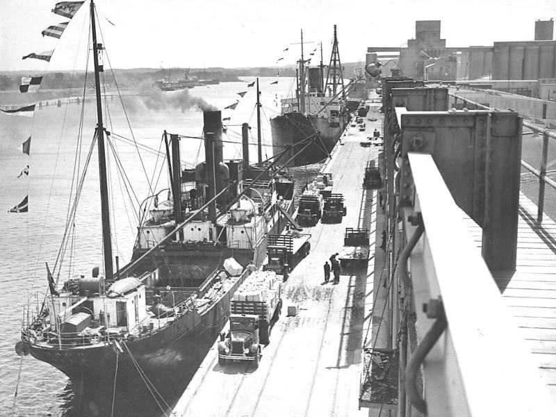 Black and white image of the Port doc receiving a shipment of Swedish wood pulp