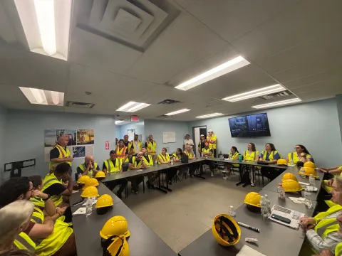 Group wearing safety yellow PPE listening to presentation in Security Training Room