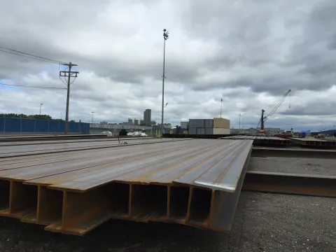 steel beams lined up for storage in the maritime terminal with the Empire State Plaza in the background