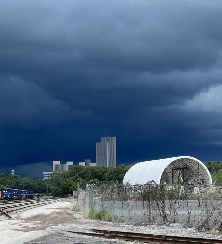 storm clouds over Albany skyline with C.D. Mann in the foreground