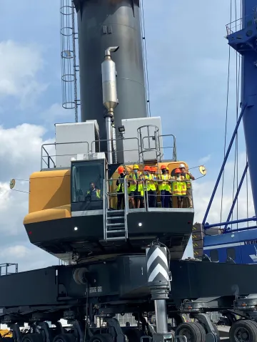 students in safety gear experience perspective from mobile crane 