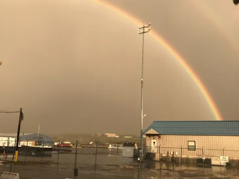 Double rainbow in a gray sky above Security building