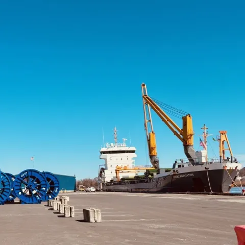 Large ship with crane in the background and CHP cable spools to the left