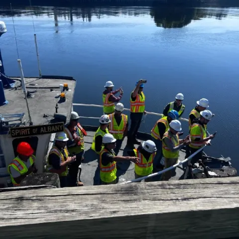 Potential sub-contractors on pre-bid river side tour for wharf renovation
