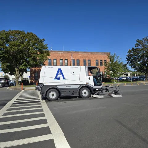 street sweeper with Port A wordmark in front of the Port Administration building
