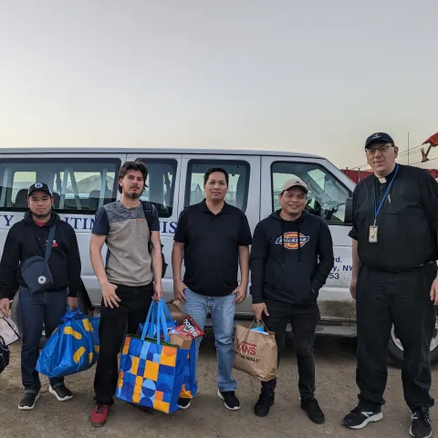 group of seafarers with shopping bags in front of Maritime transport van with Rev. Chilton