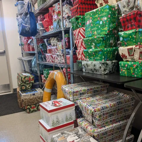 shelves of Christmas at Sea boxes wrapped in colorful holiday paper