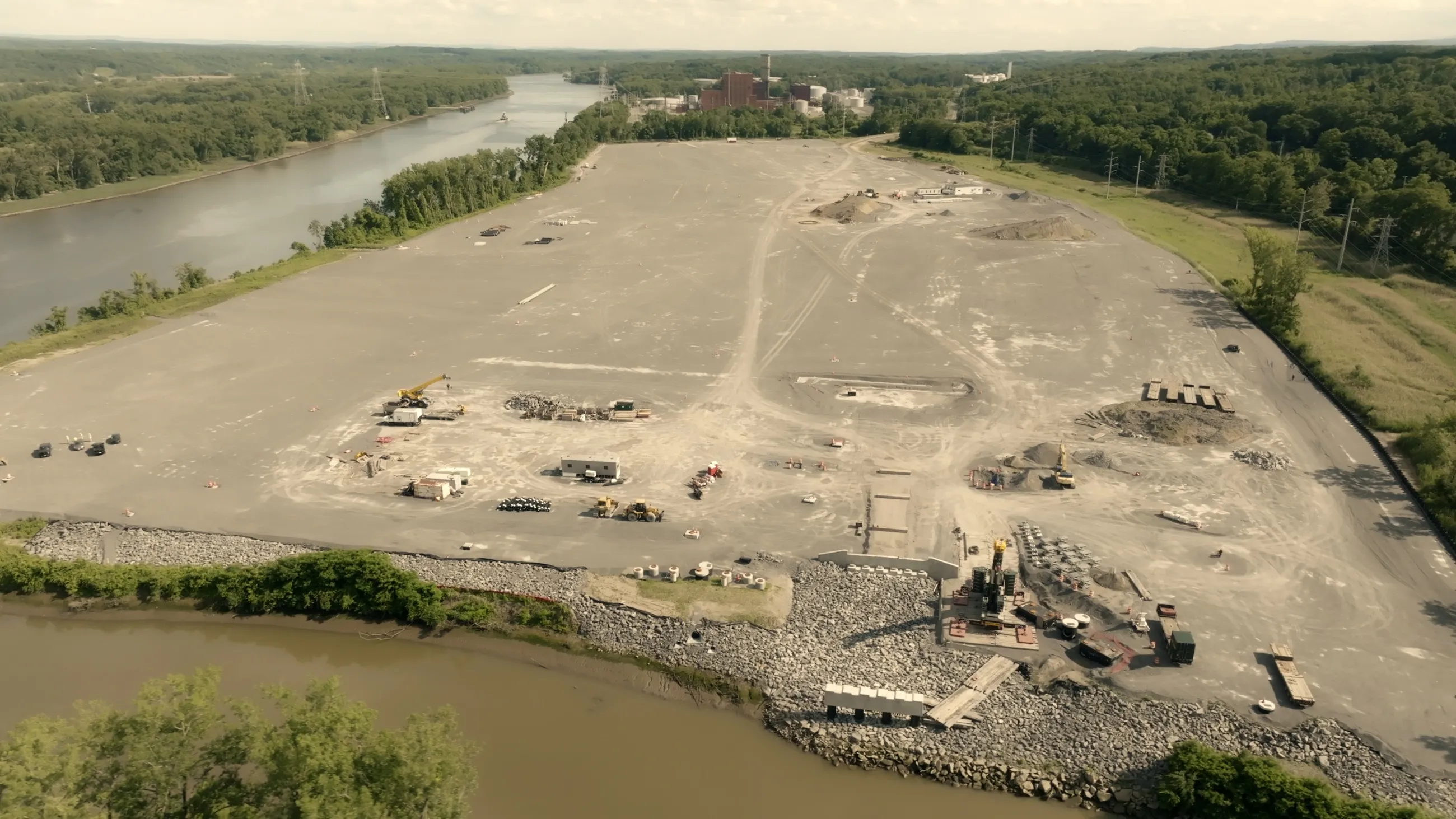 Overhead view of a cleared plot of land with heavy machinery vehicles