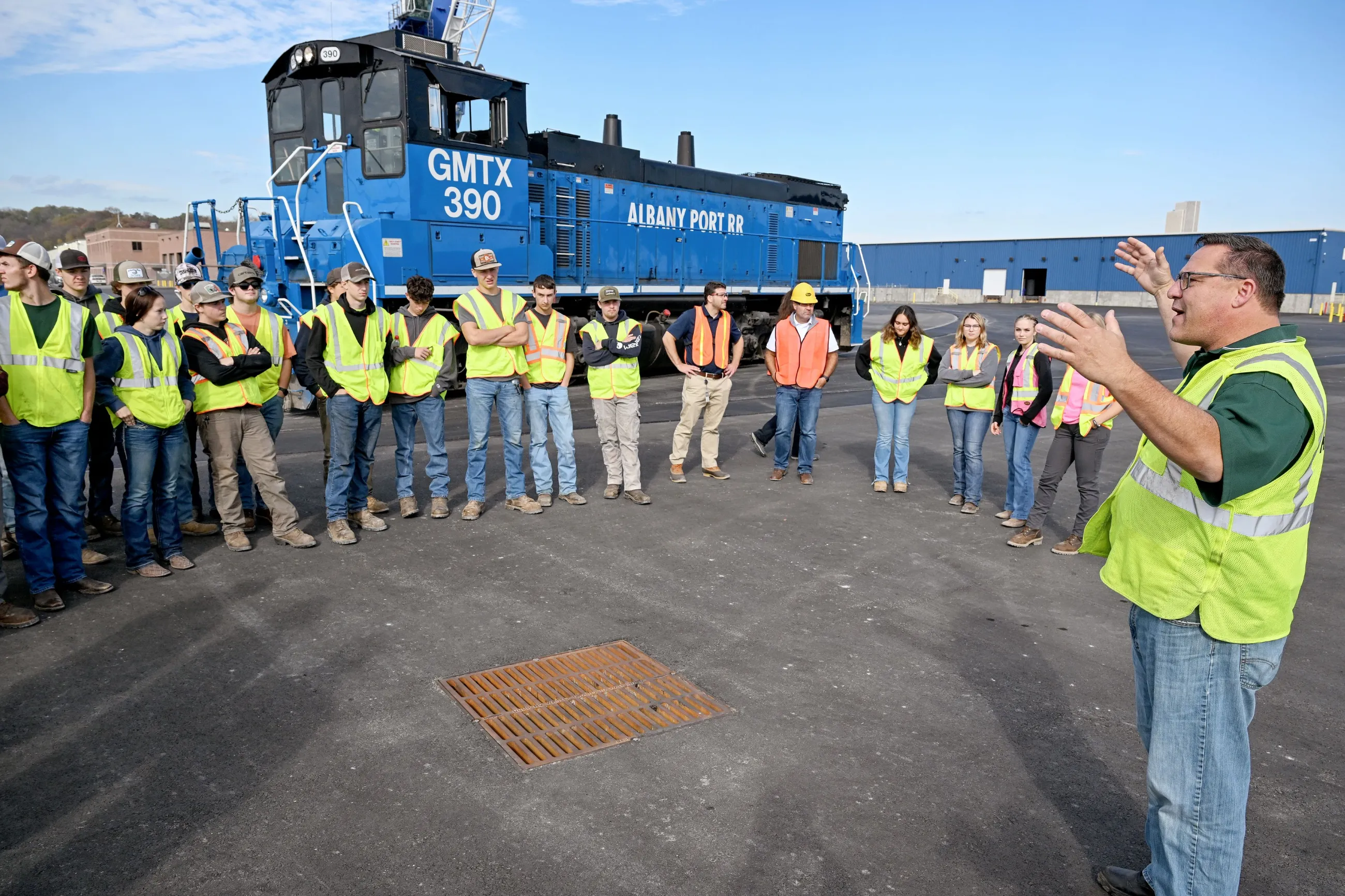 Port crew in yellow vests meets in a semi-circle outside