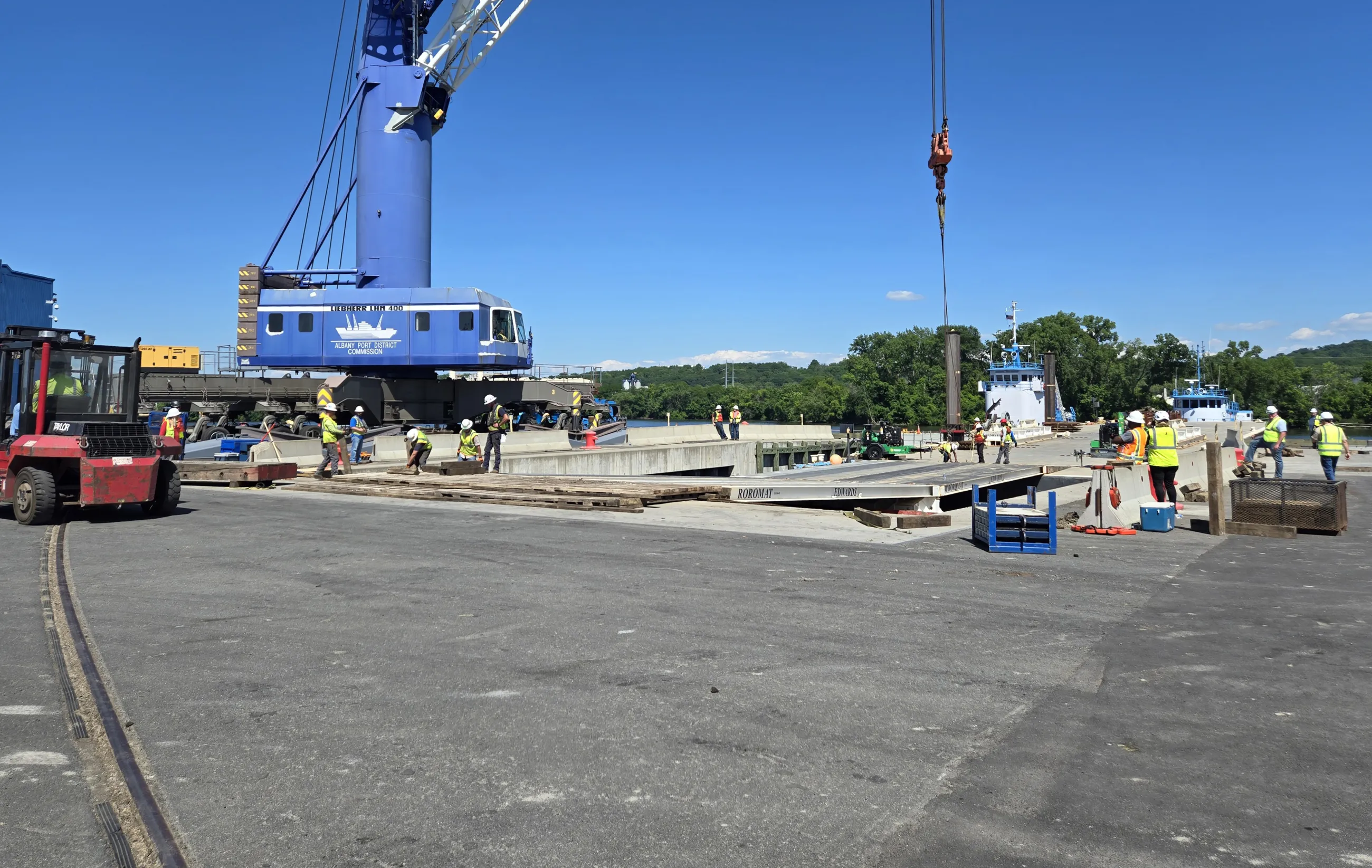 Port employees doing various tasks near a crane