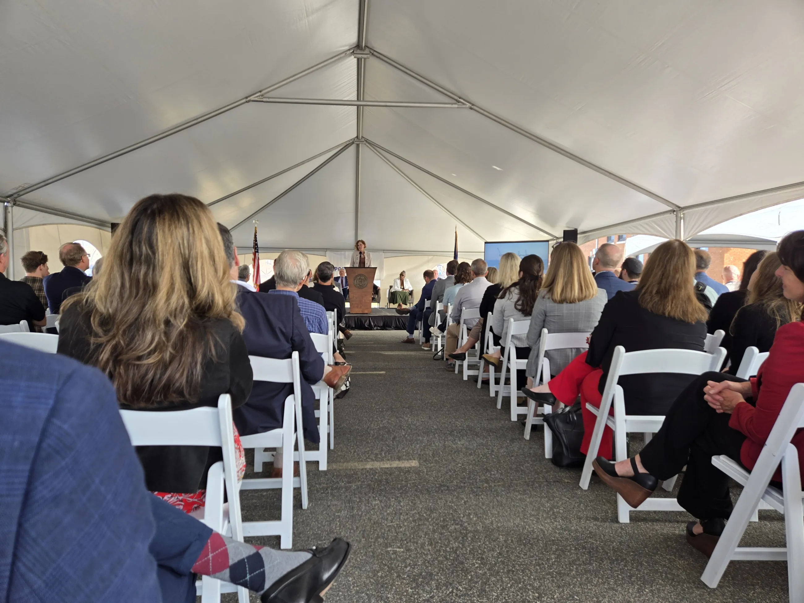 view down the center aisle of a tent to a speaker at the podium